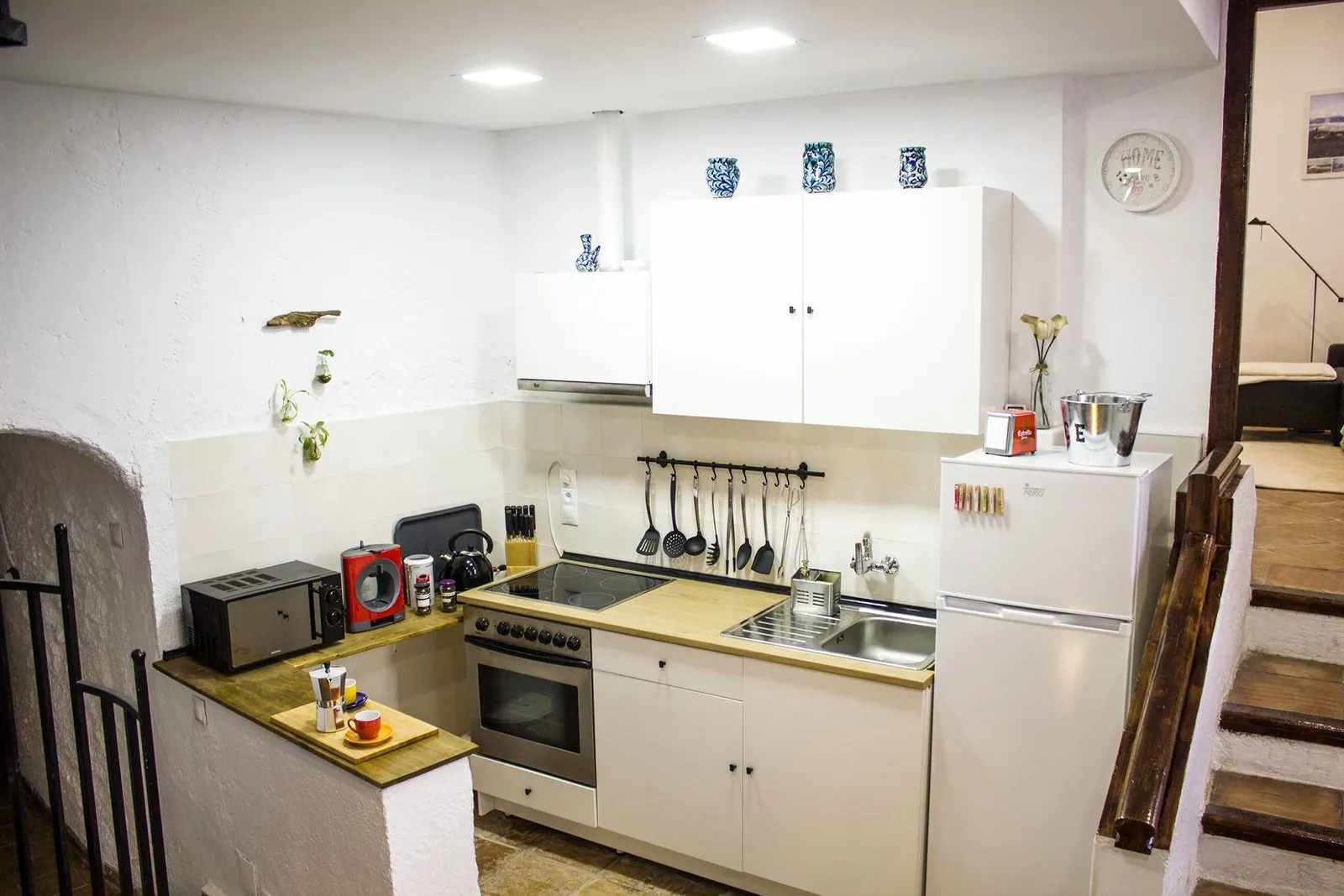 General view of the kitchen with fridge, oven and wooden worktop