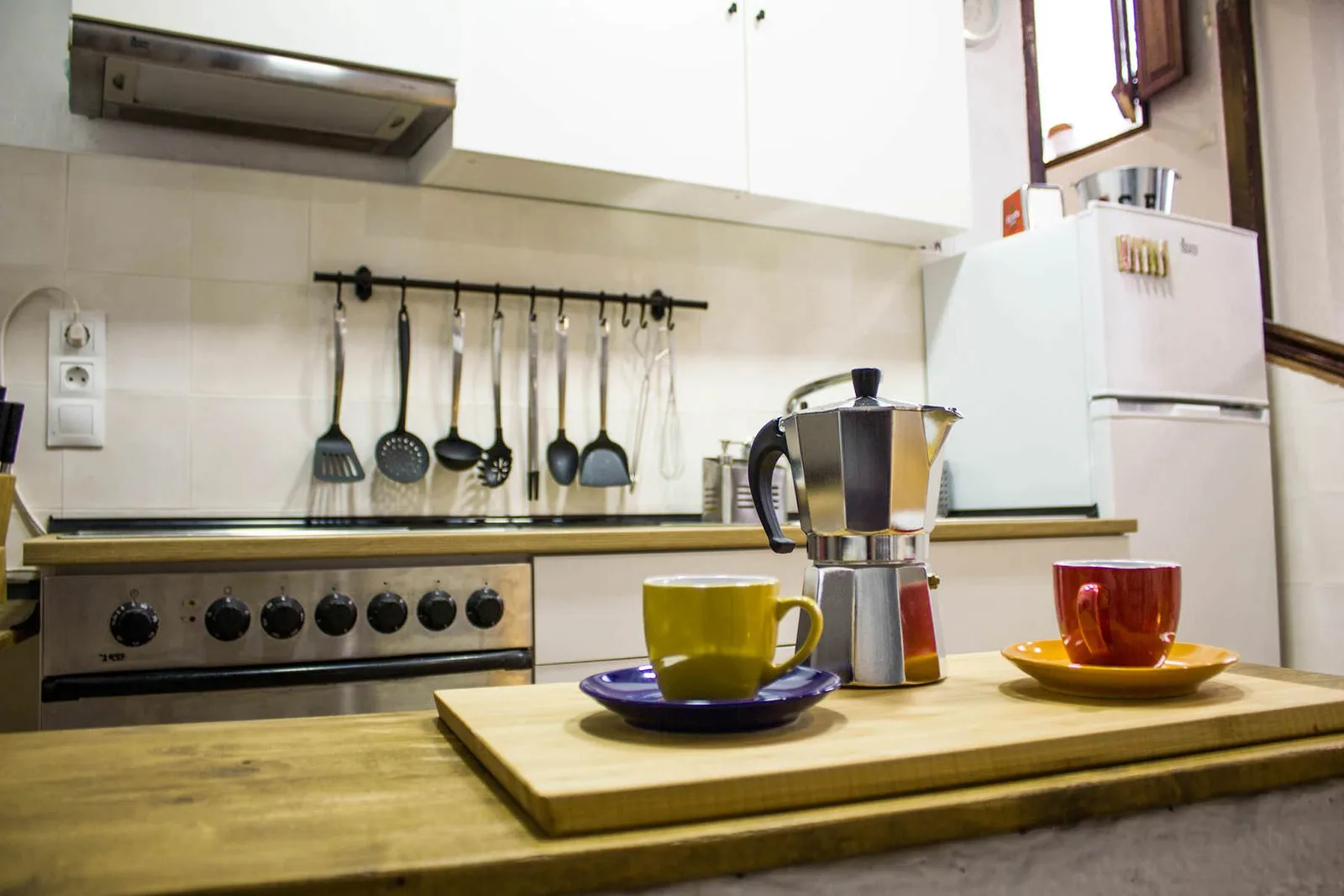 Kitchen worktop with a moka pot and colourful cups