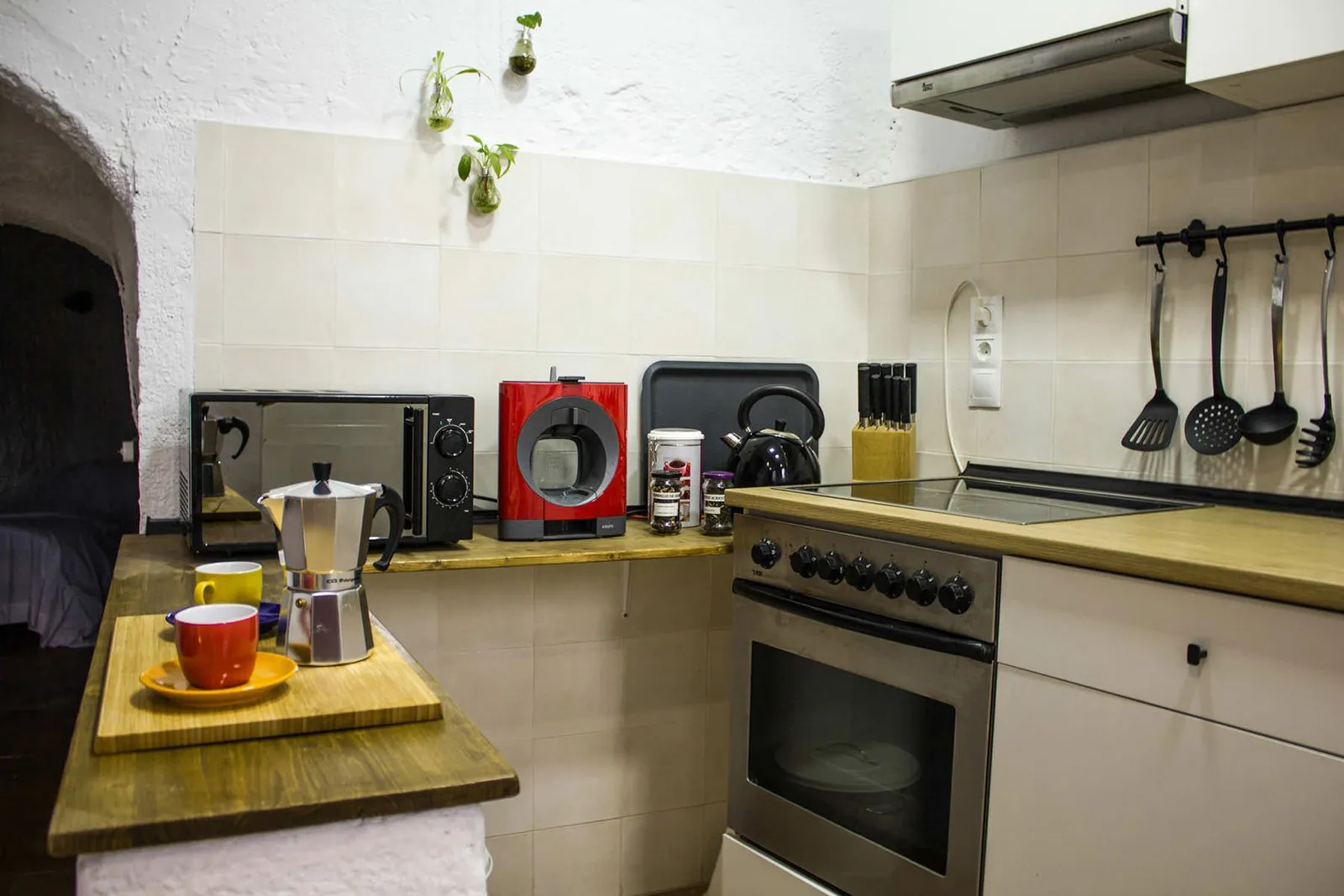 Kitchen with microwave, toaster and hanging utensils