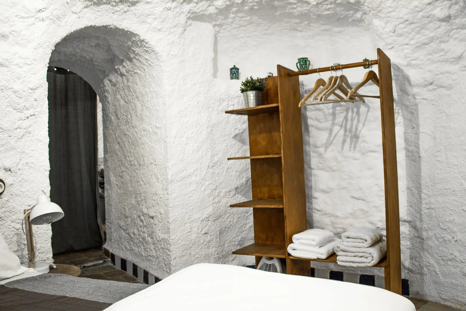 Wardrobe area with hangers and traditional pottery in the alcove