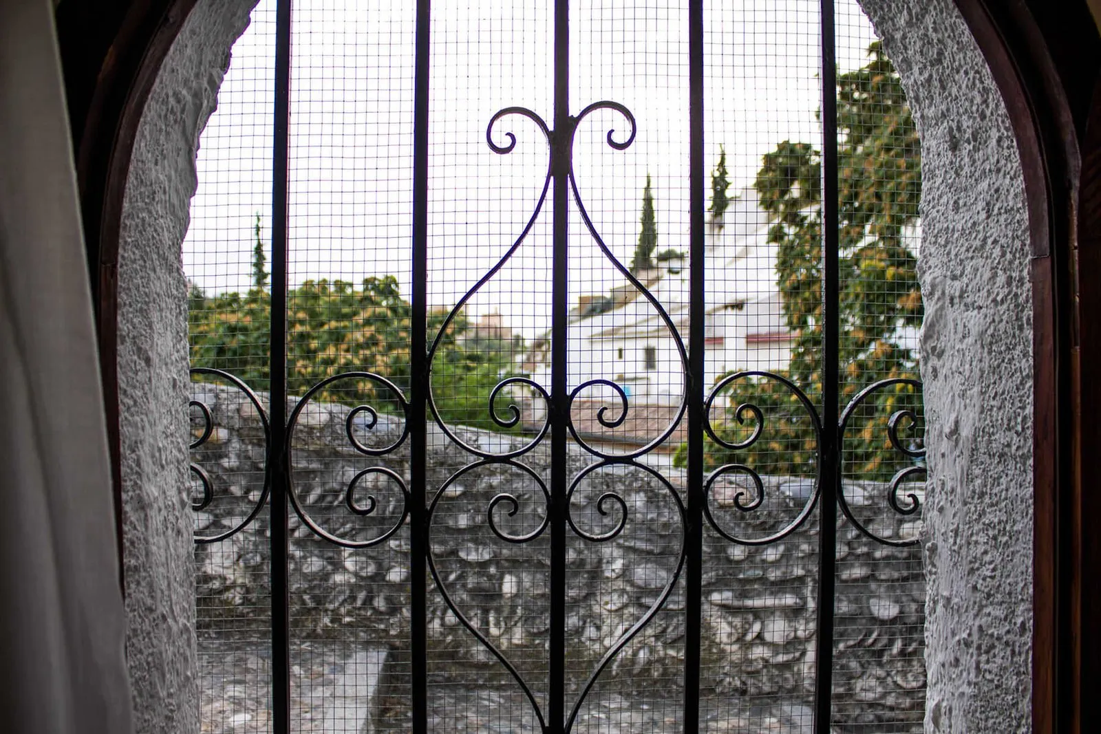 Window with a wrought-iron grille looking out over the Sacromonte