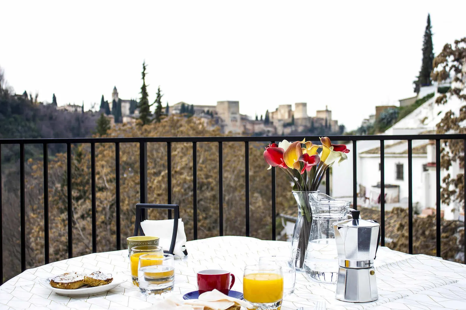 Table with breakfast on the terrace facing the Alhambra