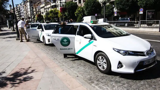 White Granada taxi with the diagonal green stripe along its side